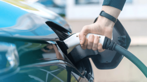 man-plugging-charger-into-electric-car-charge-station_1268-17697